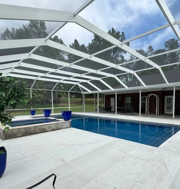 pool and spa inside a white screened enclosure with tile deck