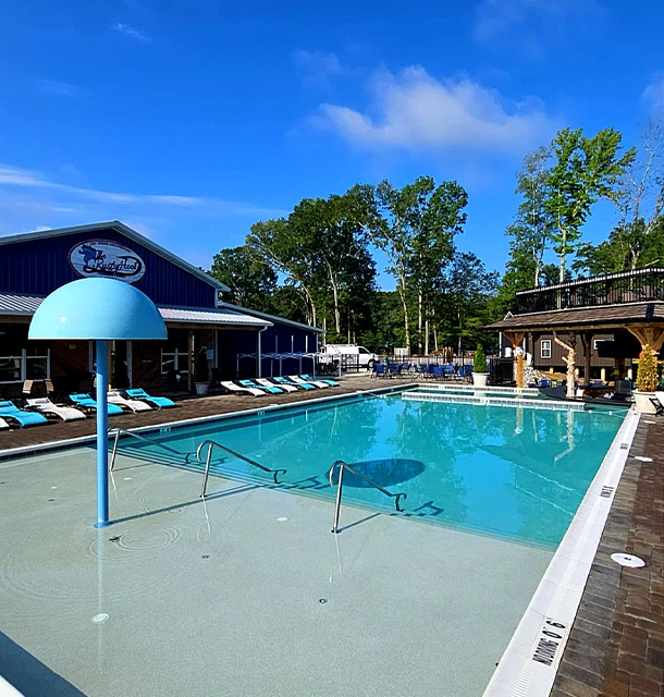 commercial-style pool with zero-entry steps and lounge chairs